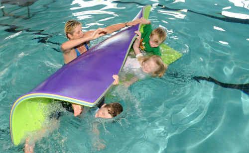 Swimming instructor Anne McDonnell tips fully-clothed students Bailey Nolan, 5; Olivia Kahler, 4; and Johnathon Tydings, 3; into the water to teach them how to react in an emergency. Swimming instructor Anne McDonnell tips fully-clothed students Bailey Nolan, 5; Olivia Kahler, 4; and Johnathon Tydings, 3; into the water to teach them how to react in an emergency.